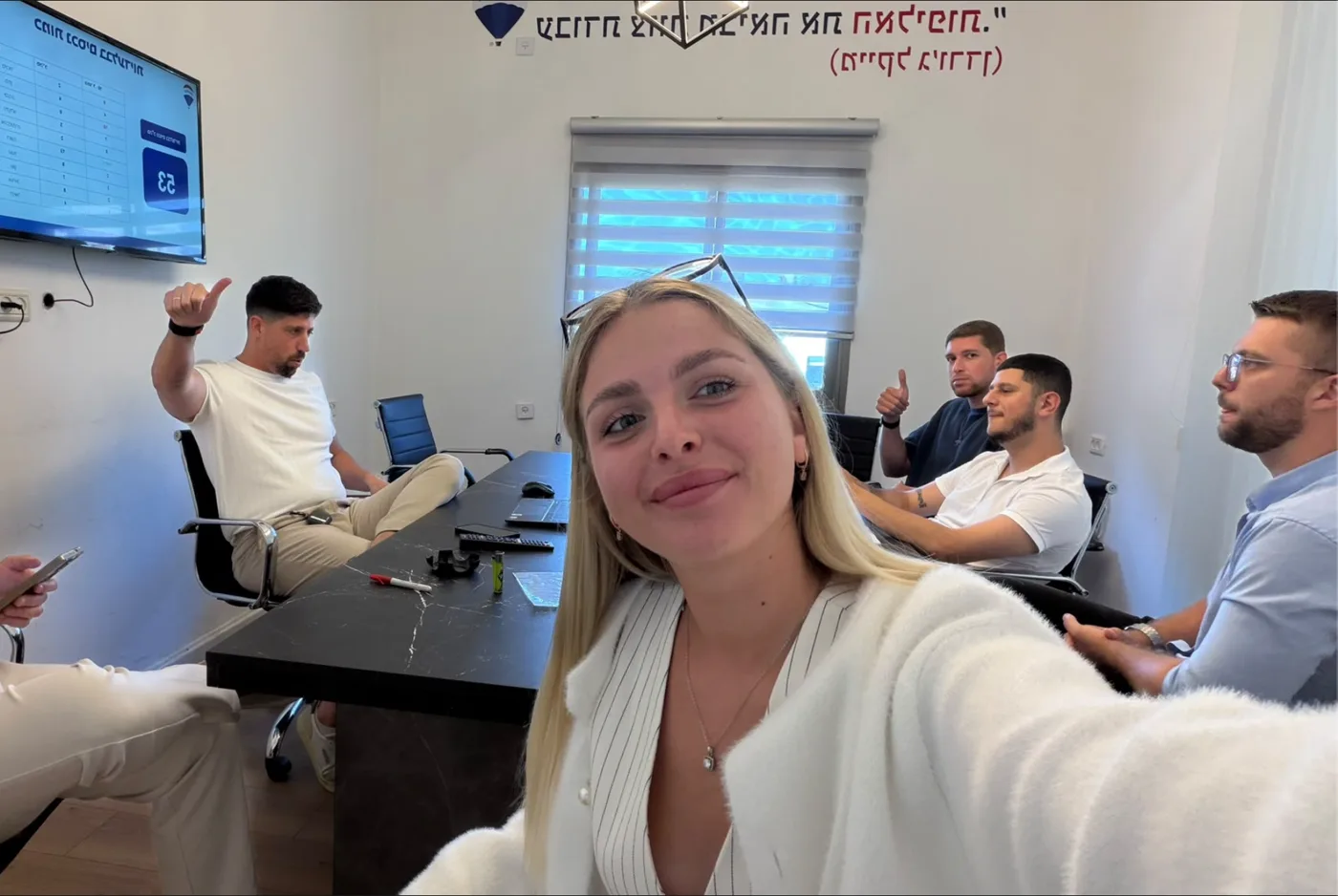 ישיבת צוות בחדר הישיבות של המשרד, מול לוח היעדים